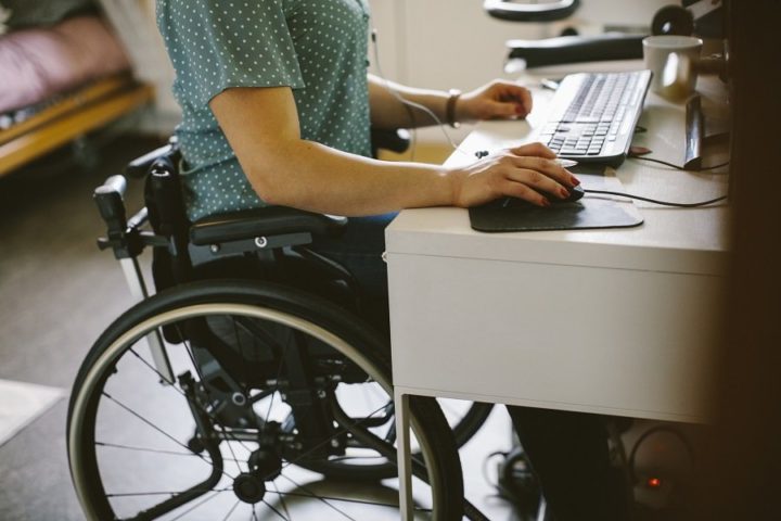 mulher em cadeira de rodas usando um computador